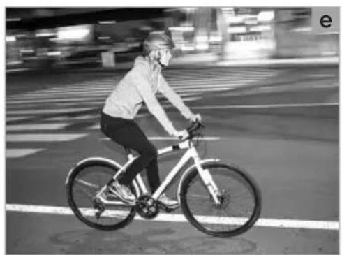Person riding a bicycle on a city street at night (no visible text or symbols)