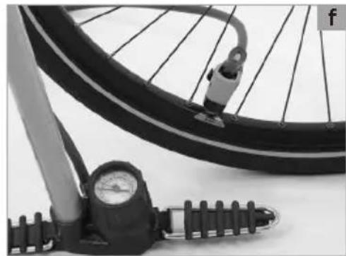 Close-up of a bicycle wheel with pressure gauge and mechanical components (no visible text or symbols)