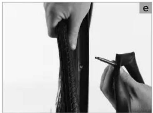 Close-up of hands holding a black textured object with a pen, no visible text or symbols