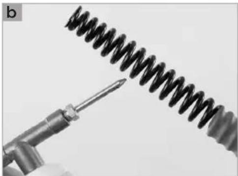Close-up of a medical or laboratory procedure showing a tool interacting with a coiled spring-like object (no text or symbols visible)