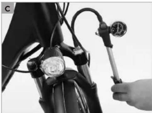 Close-up of a hand adjusting a pressure gauge on a motorcycle's head (no text or symbols visible)