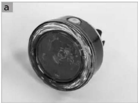 Close-up of a black cylindrical electronic component with a reflective top and small protrusions (no visible text or symbols)