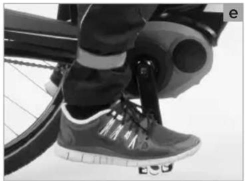 Close-up of a person's lower body and foot wearing a Nike shoes, seated on a bicycle (no visible text or symbols)