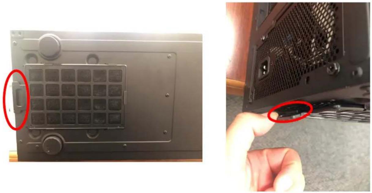 Close-up of a black electronic device panel with a grid of buttons and a red-circled button, being held by a hand holding a cable (no visible text or symbols)