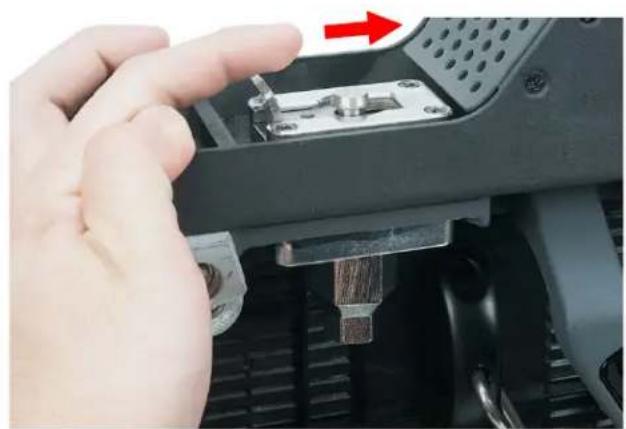 Close-up of a hand inserting a component into a device, showing a red arrow indicating direction (no text or symbols visible)