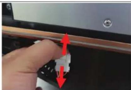 Close-up of a hand holding a small electronic component with red arrows indicating direction (no text or symbols visible).
