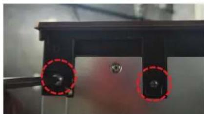 Close-up of a mechanical component with two red-circled holes (no visible text or symbols)