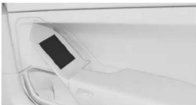 Close-up of a car's side panel with a black rectangular cover, no visible text or symbols