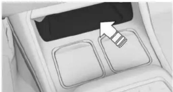 Interior view of a vehicle dashboard with two square buttons and a highlighted arrow pointing to the top panel (no text or symbols)