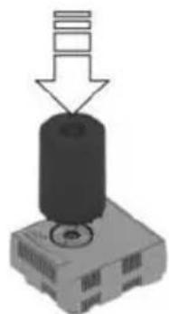 Mechanical component with a cylindrical top and base, showing a downward arrow indicating force or assembly (no text or symbols present)