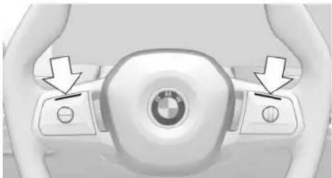 Top-down view of a car steering wheel with BMW logo and directional arrows indicating control buttons (no text or symbols on the main body)