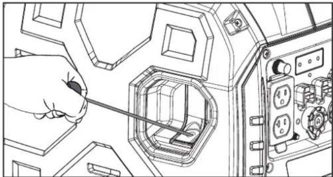 Line drawing of a hand using a screwdriver to adjust or install a mechanical component inside a control panel (no text or symbols visible)