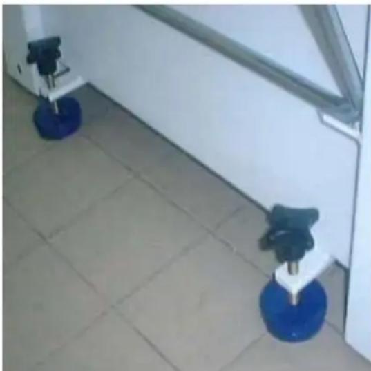 Two blue circular objects on tiled floor next to a white wall, no visible text or symbols