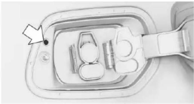 Top-down view of a medical device component with a black dot and arrow pointing to it (no visible text or symbols)