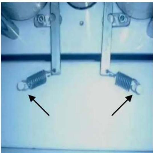 Close-up of two mechanical components with arrows pointing to them, no visible text or symbols