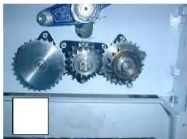 Mechanical gear assembly with three meshed gears and a blue mechanical component (no visible text or symbols)
