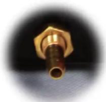 Close-up of a brass connector with a pointed tip, against a dark circular background (no text or symbols visible)