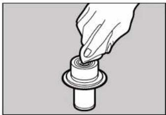 Hand pressing a cylindrical component on a base (no text or symbols visible)