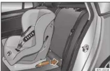 Interior view of a car showing a car seatbelt and door, with a directional arrow indicating a specific component (no text or symbols present)