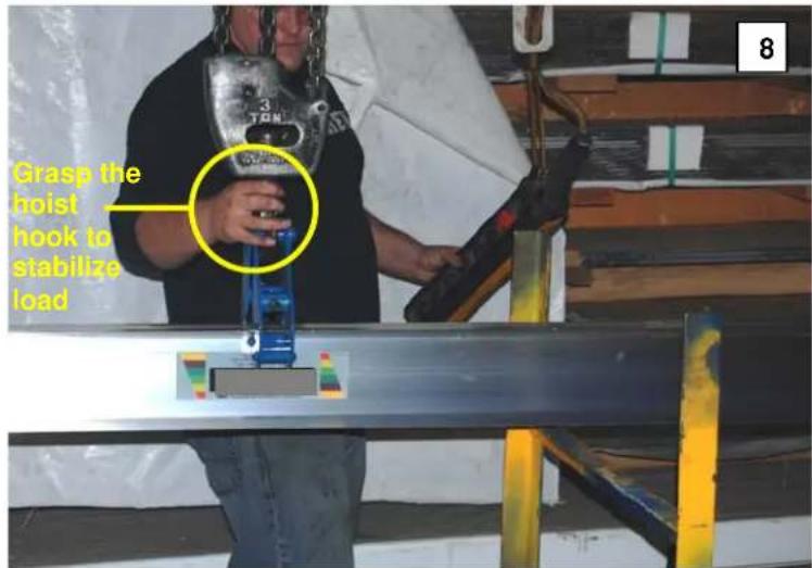 Grasp the hoist hook to stabilize load