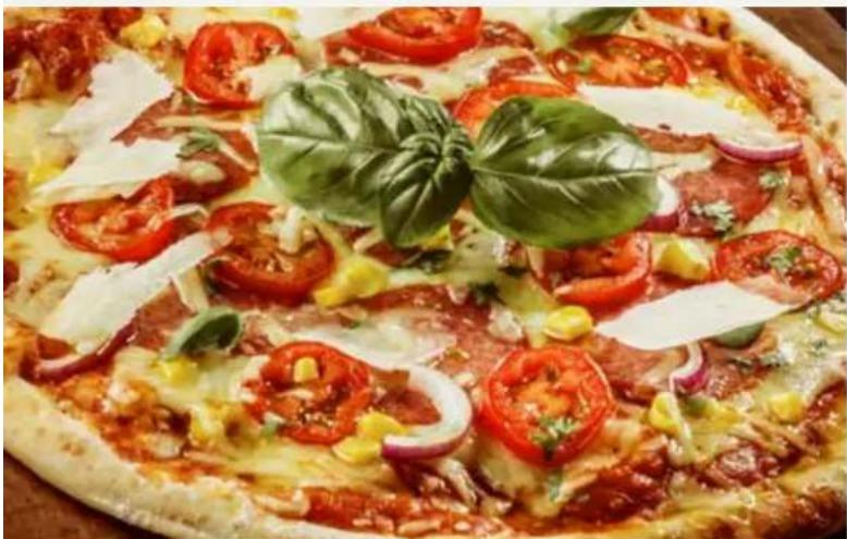 Close-up of a colorful pizza with tomatoes, corn, cheese, and herbs (no text or symbols visible)