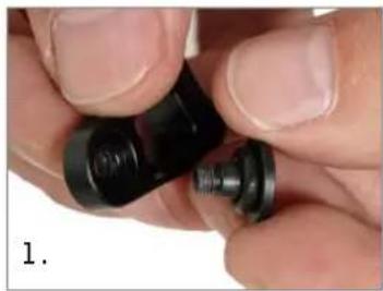 Close-up of hands holding a black mechanical component with a small threaded part (no visible text or symbols)
