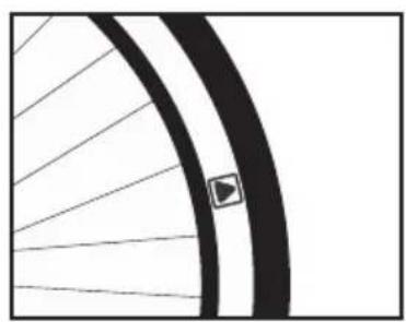 Close-up of a bicycle wheel rim with visible spokes and a small triangular symbol on the wheel (no text or labels)