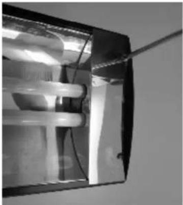 Close-up of a transparent cylindrical device with internal components and wiring (no visible text or symbols)