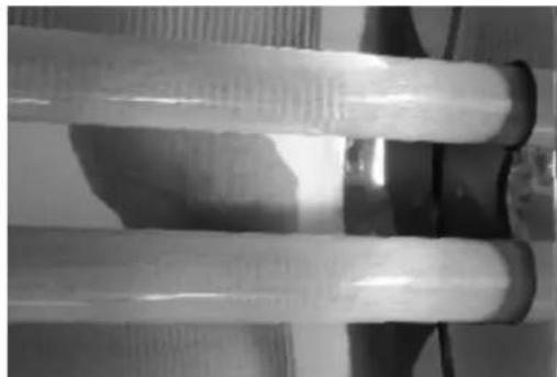 Close-up of two transparent cylindrical objects with textured surfaces, possibly industrial or mechanical components (no visible text or symbols)