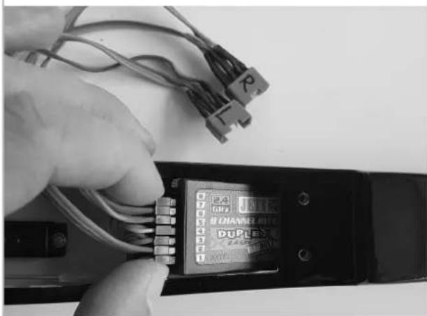 Close-up of a hand inserting wires into a device labeled 'DUPLEX' (no readable text beyond labels)