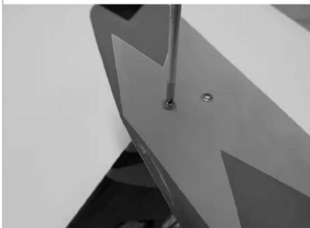 Close-up of a metallic mechanical component with a screwdriver inserted, showing no visible text or symbols.