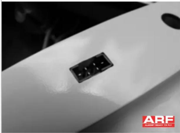 Close-up of a white electronic device with a black connector and a circular port, no visible text or symbols.
