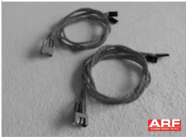 Two coiled cable connectors with connector pins, placed on a plain surface (no text or symbols visible)