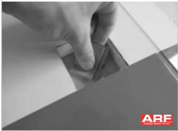 Close-up of a hand pressing down on a mechanical component, with 'ABE ALAMIN' logo visible in the corner (no readable text or symbols on the main subject)
