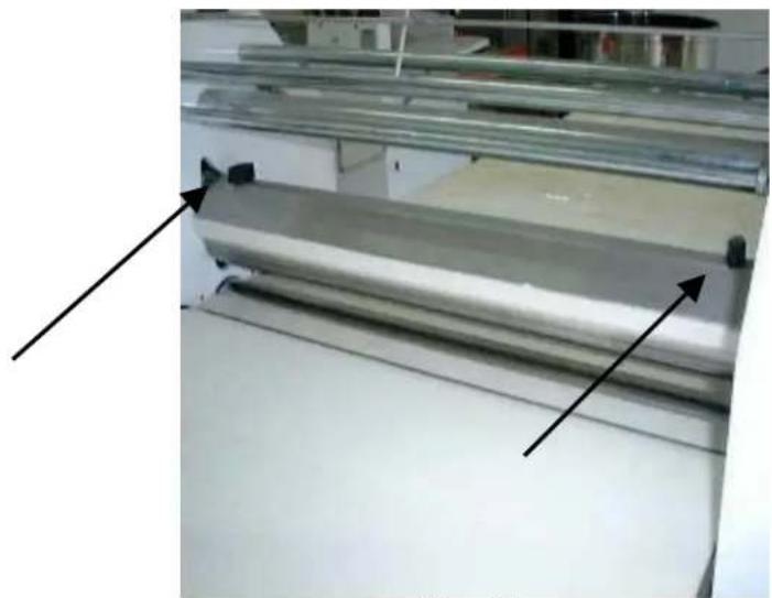 Industrial machinery with metal sheets and black arrows indicating directional movement (no visible text or symbols)
