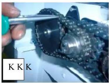 Close-up of a hand using a tool to inspect a mechanical component (no visible text or symbols)