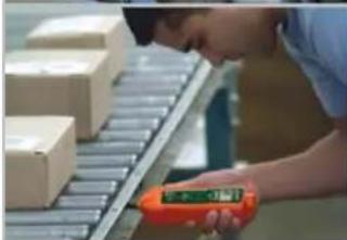 Person inspecting a conveyor belt with a handheld device (no visible text or symbols)