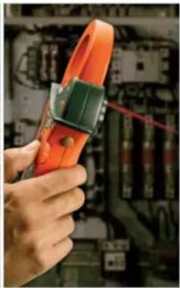 Close-up of hands holding an orange pliers with a green clamp, inspecting electrical wiring (no visible text or symbols)