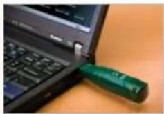 Close-up of a green screwdriver resting on a black laptop keyboard (no visible text or symbols)