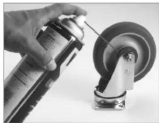 Hand spraying spray onto a car wheel (no text or symbols visible)