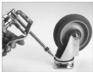Close-up of a hand using a tool to adjust a car wheel component (no visible text or symbols)