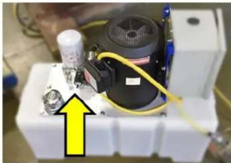Close-up of a mechanical device with yellow arrow pointing to a component (no visible text or symbols)