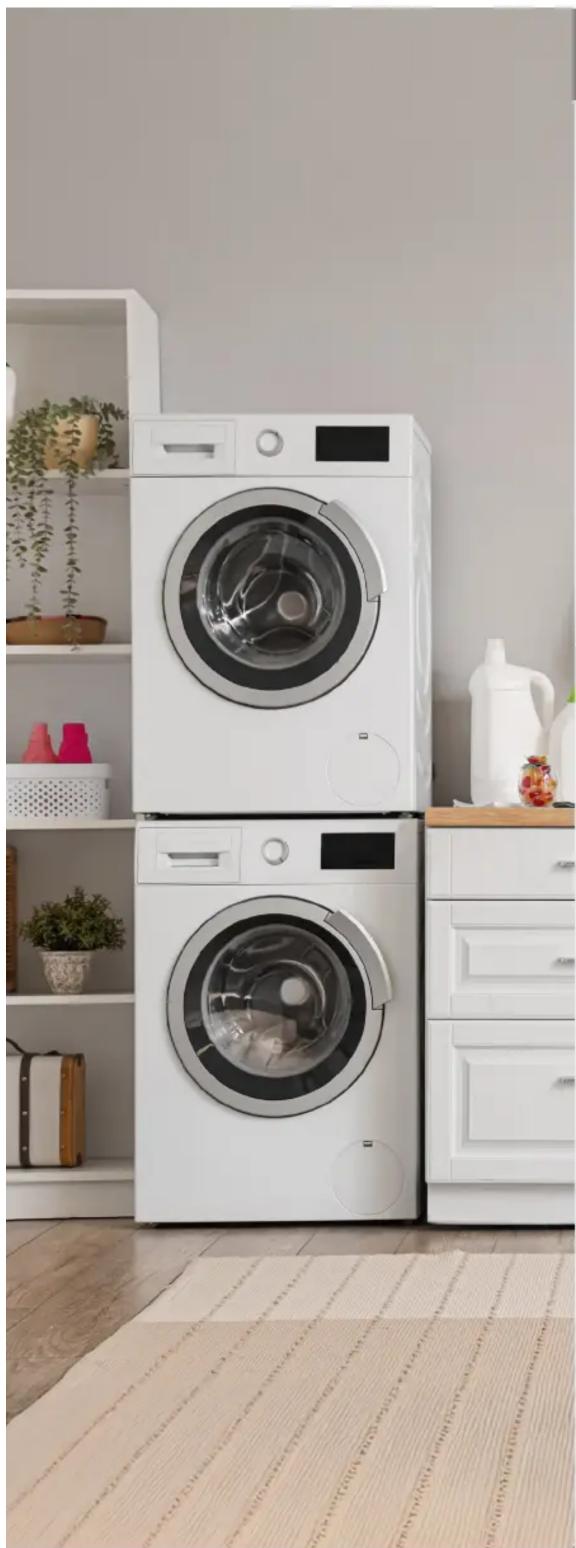 Intérieur de cuisine moderne avec des machines à laver blanches et un comptoir en bois, sans texte ni symboles visibles