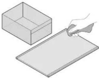 Illustration of a hand holding a tool next to a blank cardboard box (no text or symbols)