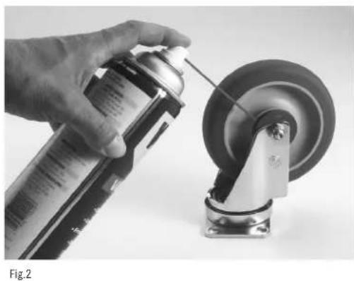 Vaporisation manuelle de spray sur une roue de voiture (aucun texte ou symbole visible)