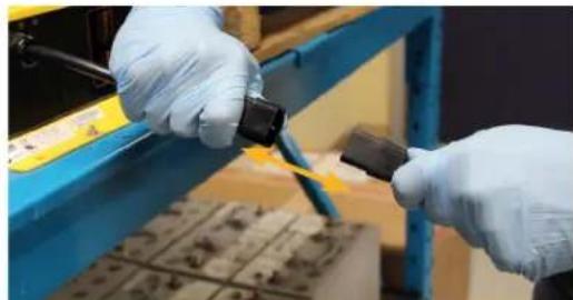 Close-up of gloved hands performing a manual task with tools and components (no visible text or symbols)