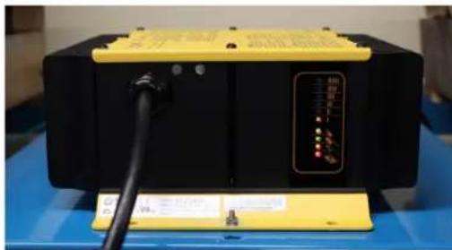 Exterior view of a black industrial machine with yellow top panel and control panel (no visible text or symbols)