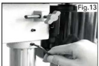 Close-up of a hand holding a tool near a metallic component, labeled Fig.13 (no visible text or symbols on the object itself)