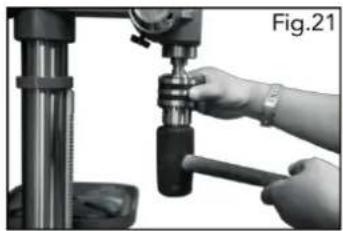 Close-up of hands operating a drill press machine (no visible text or symbols)