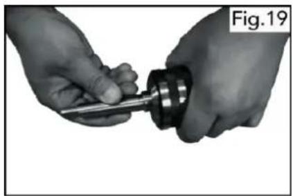 Close-up of hands holding a mechanical component, no visible text or symbols